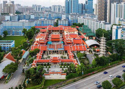 Aerial view of the majestic Lian Shan Shuang Lin Monastery rises with its vibrant red roofs and intricate carvings against the modern cityscape, Singapore, Singapore.