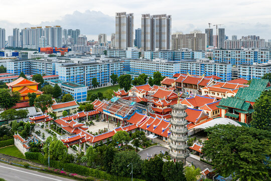 Aerial view of the vibrant red-roofed Lian Shan Shuang Lin Monastery nestled amidst modern buildings, a serene splash of tradition, Singapore, Singapore.