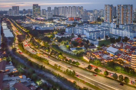 Aerial view of the Pan Island Expressway cutting through the heart of Toa Payoh, illuminating Singapore with streams of light against the twilight sky, Singapore, Singapore.