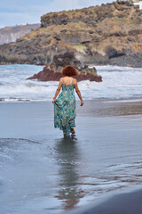 Woman walking into ocean waves