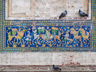 Colorful kashi-kari mosaic scene with camels on historic Picture Wall built by mughal emperor Jahangir in Lahore fort, Punjab, Pakistan