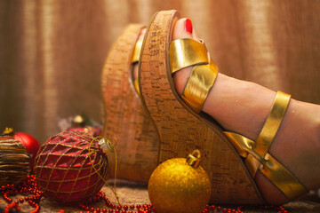 women's feet in platform sandals and Christmas tree balls