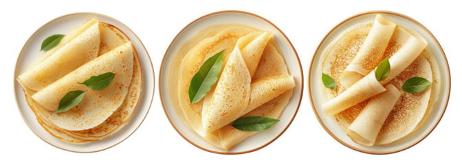 Thin golden crepes folded on a white plate with green leaves, isolated on white background, concept of breakfast