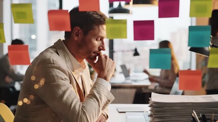 Business professional in office environment with wall covered in sticky notes for brainstorming and project planning. Modern workplace collaboration with documents on desk, team members in background - Powered by Adobe