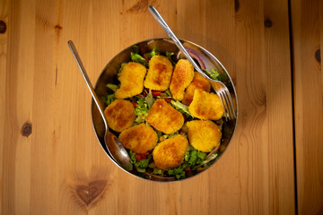 Salad with Nuggets in Chrome Bowl on Wooden Table
