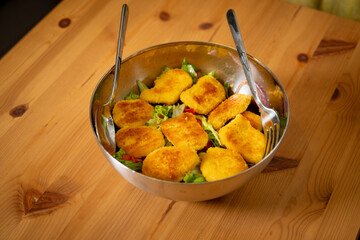 Salad with Nuggets in Chrome Bowl on Wooden Table