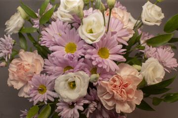 closeup pastel bouquet with daisies and lisianthus, stylist demonstrating mindful floral therapy, soft petals, textured foliage