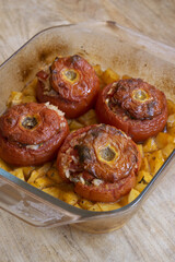 baked stuffed tomatoes with rice in glass baking dish