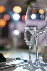 Glasses placed on table with blurred lights in background