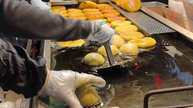 Food vendor perfects technique through repetition. Preparing artisan craft requires focus, specialized skill. Food vendor delivers fresh, handmade artisan craft.