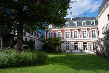Fototapeta premium In Mont de Marsan, the stunning city hall building features classic architecture surrounded by green gardens. Visitors can admire the elegant design and peaceful atmosphere on a bright day.