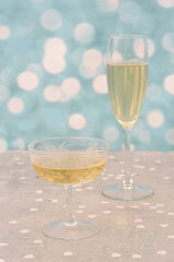 Romantic picture for Valentine's Day, wedding, anniversary or so on. Two different glasses of champagne, hearts on light, shiny, blue background.