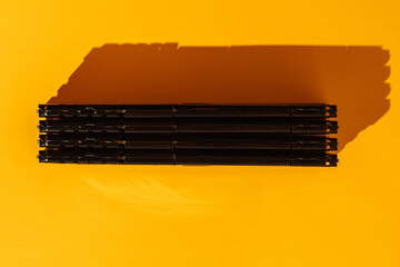 Four black RAM modules stacked horizontally on yellow background. High quality photo