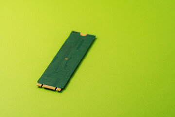 Single M.2 NVMe SSD on bright green background with copy space. High quality photo