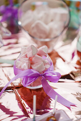Bowl of pink candies on shiny table surface at party