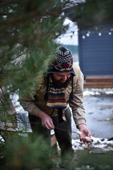 Adult man in winter clothes putting marshmallows on a stick for roasting