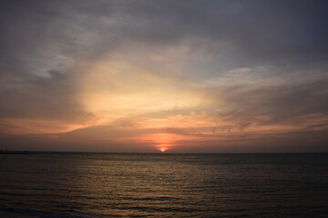 Fototapeta premium Breathtaking tropical seascape at golden hour/sunset, with sunlight reflecting on the calm ocean surface. Ideal for travel, background, and tranquility themes