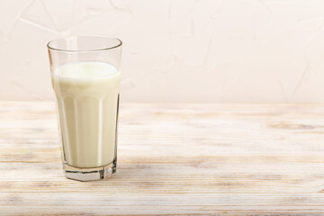 Glass of milk. Fresh glass of milk placed on rustic wooden table, showcasing its creamy texture and inviting appearance, illuminated by soft natural lighting, creating warm and cozy atmosphere
