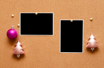 Empty photos and Christmas tree toys are pinned on a cork board. Copy space