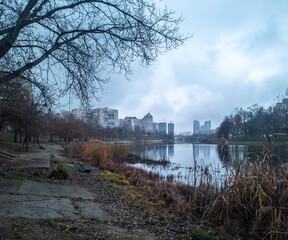 Obraz premium City skyline reflecting on park lake during autumn twilight
