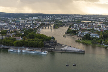 Aerial view of Deutsches Eck where the Mosel joins the Rhine, under a cloudy sky, with boats docked, Koblenz, Rhineland-Palatinate, Germany.