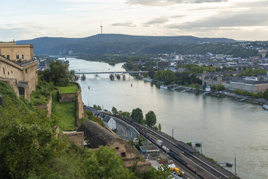 Aerial view of the confluence of the Rhine and Moselle rivers with Ehrenbreitstein Fortress and Deutsches Eck, under a soft sky, Koblenz, Rhineland-Palatinate, Germany.