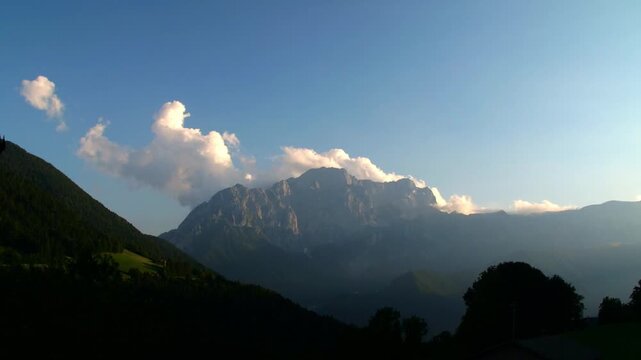 Aerial Golden hour timelapse of clouds forming behind the rocky Presolana peak in Val di Scalve, Orobie Alps. Majestic Italian mountain sunset with dramatic glowing sky