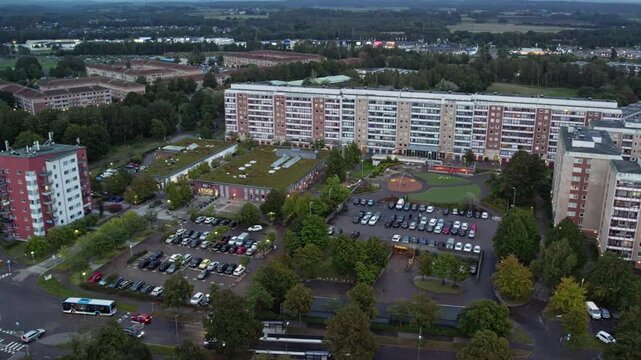 South Halmstad, Sweden - A Large Residential Complex Surrounded by Parking Areas, Trees, and Busy Streets at Dusk - Aerial Drone Shot