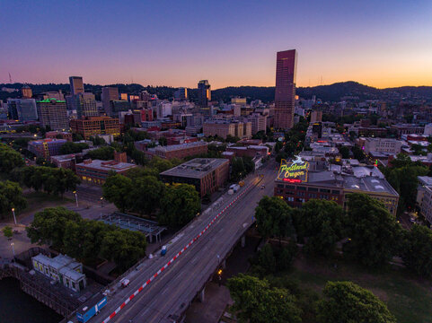 Portland, United States - 17 July 2018: Aerial view of the city's heart, where the US Bancorp Tower pierces the twilight sky, framed by the West Hills and the Willamette River.