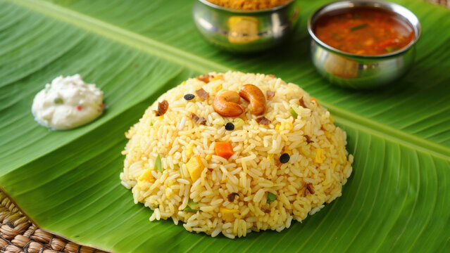 Traditional pongal rice on banana leaf, harvest meal with sweet chakkara pongal, savory venn pongal, manjal kothu garnish, roasted cashew, lentil tempering, turmeric, sambar, curd pachadi