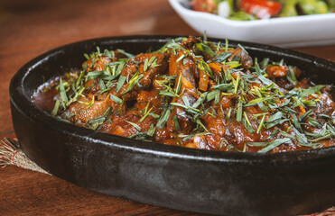 Oriental cuisine:  meat with vegetables and onion in a bowl close-up on the table.