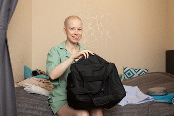 Bald woman with cancer packing a hospital bag at home, concept of preparation for treatment, health journey, and emotional strength.