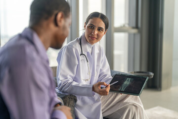 Woman doctor explaining brain CT scan results to male patient with medical consultation sitting at table with x-ray in modern hospital, neurology checkup, diagnosis, supportive healthcare talk, stroke