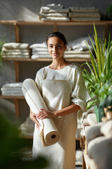 Young Woman Holding Fabric Roll in Eco Textile Workshop with Natural Light