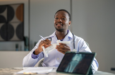 Fototapeta premium African doctor showing knee joint X-ray on tablet and bone model with patient, orthopedic consultation telemedicine appointment, diagnostics musculoskeletal health awareness, osteoarthritis and gout