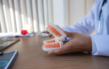 Dentist examining patient’s teeth, explaining oral health issues, reviewing x-rays, planning...