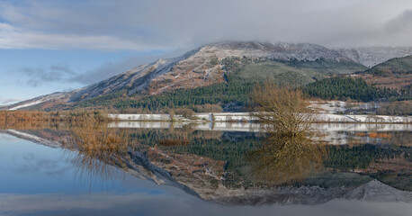 Fototapeta premium Snowy Mountain Reflected in a Still Lake Surface Under a Blue Sky