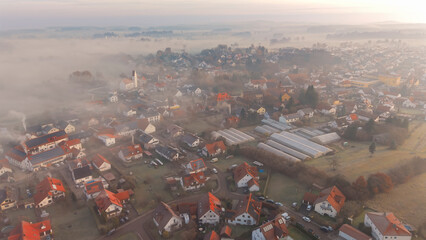 Foggy Bavarian landscape during morning sunrise phase with forest background and small village close which is called P&ouml;rnbach and is located at the region of Pfaffenhofen