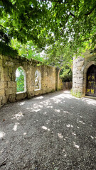 Ancient Stone Wall Ruins Along a Shaded Woodland Path