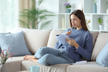 Doubtful woman thinking what to write on notebook