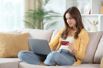 Relaxed woman in yellow buying online at home