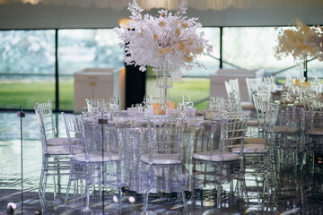Modern wedding reception with clear chairs and garden view