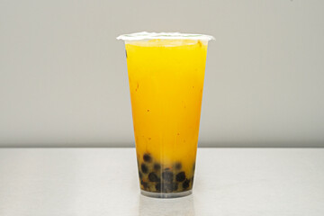 A mango-flavored bubble tea with a lid