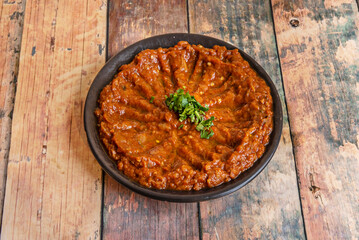 Red lentil hummus, lighter and orange in color, garnished with a drizzle of olive oil and a pinch of turmeric powder