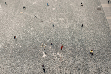 A stunning aerial shot captures a vibrant scene of people walking on a textured surface, creating...