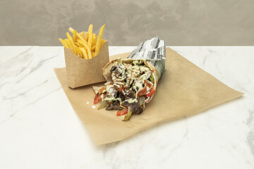 A mixed shawarma platter with thinly sliced ​​marinated chicken and beef, freshly cut from the vertical rotisserie, served on warm pita bread