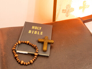 Rosary beads and crucifix cross on holy bible in church