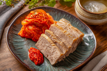 Traditional Korean Kimchi and Suyuk Pork Slices Served Together on a Rustic Plate for Authentic Winter Dining Experience