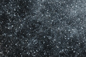 Natural black granite rock surface with mineral speckles texture.