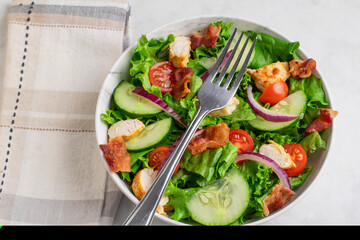 salad top with chopped bacon and hicken